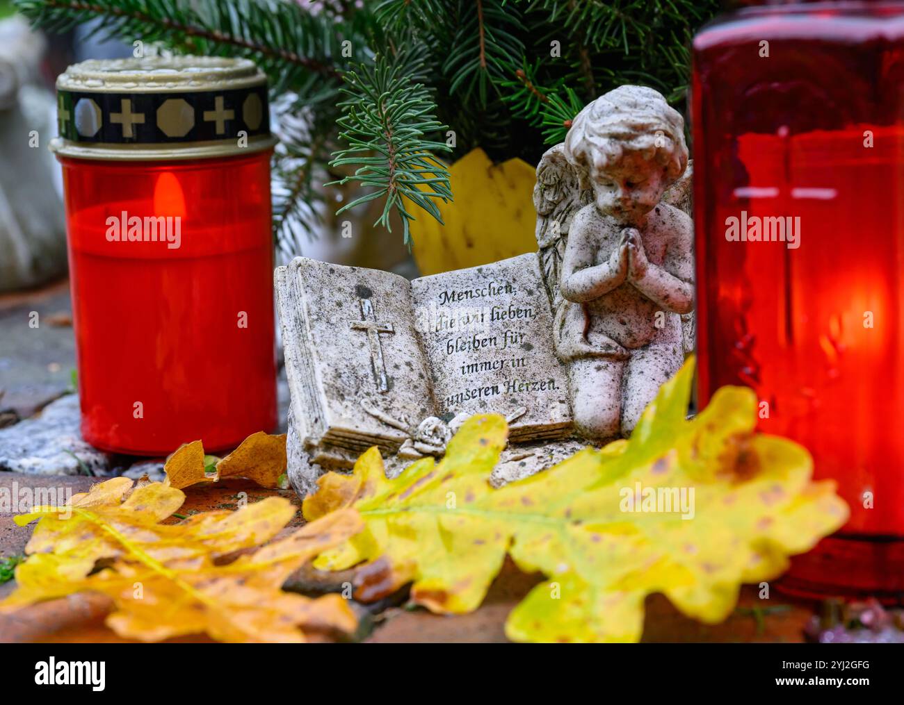 13 novembre 2024, Brandebourg, Francfort (Oder) : des bougies brûlent à côté d'une petite figurine d'ange avec le slogan "les gens que nous aimons restent pour toujours dans nos cœurs" sur une tombe du cimetière principal. Le 17 novembre 2024 est le jour du souvenir. Volkstrauertag est une journée nationale du souvenir en Allemagne et est l'une des journées dites du silence. Le jour du souvenir a été célébré deux dimanches avant le premier dimanche de l’Avent depuis 1952. Photo : Patrick Pleul/dpa Banque D'Images