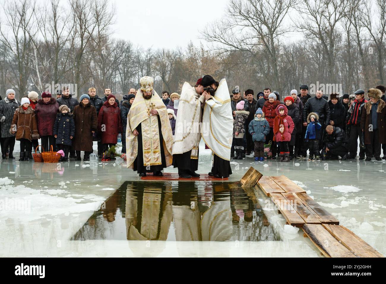 Ukraine, la ville de Romny, 19 janvier 2013 : un prêtre consacre de l'eau avec une croix dans une citerne à la fête du baptême du Seigneur. Orthodoxe R Banque D'Images