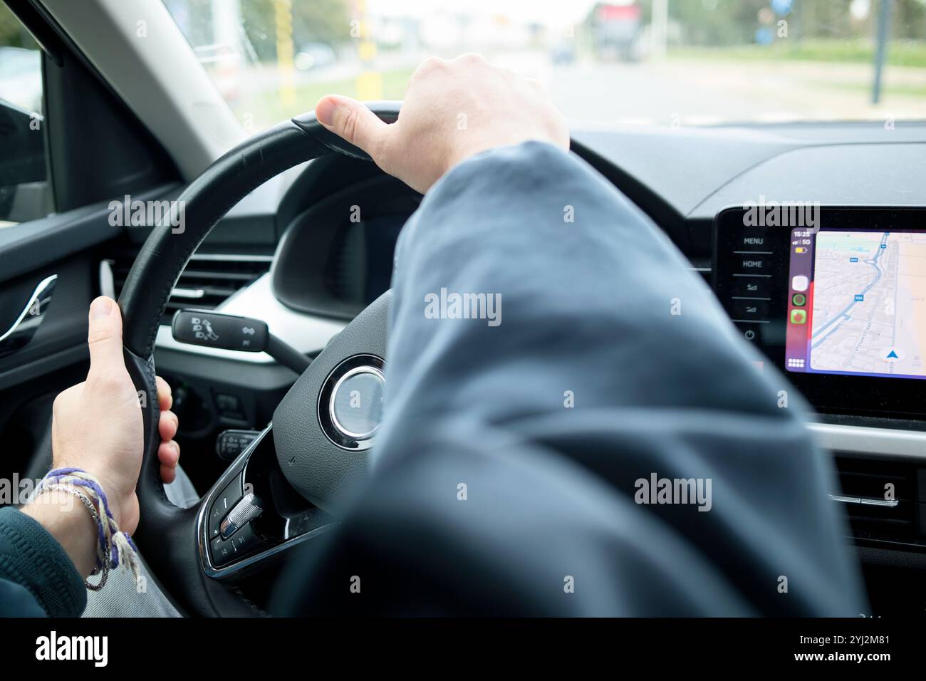 Main du conducteur sur le volant avec une carte de navigation affichée sur l'écran tactile de la voiture, Bruxelles, Belgique Banque D'Images