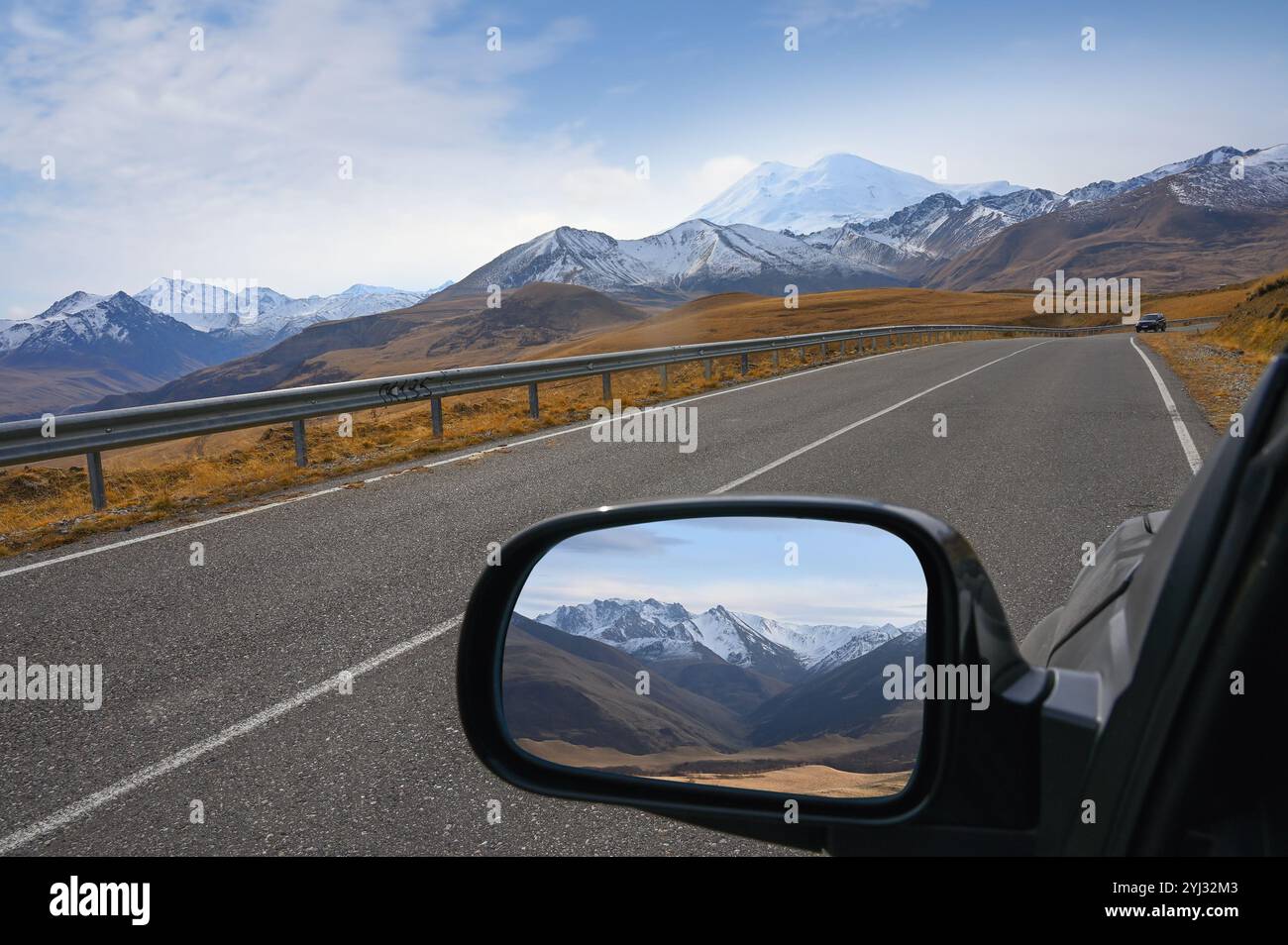 Les montagnes du Caucase sont affichées dans le rétroviseur d'une voiture sur le chemin du mont Elbrus, en Russie Banque D'Images