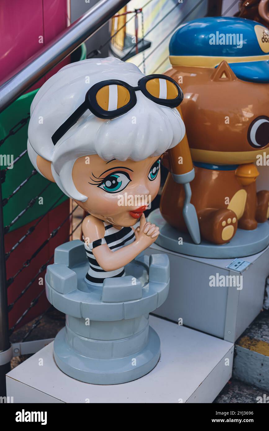 Des personnages de dessins animés colorés décorent les rues animées de Hong Kong, ajoutant une touche fantaisiste au paysage urbain. Banque D'Images