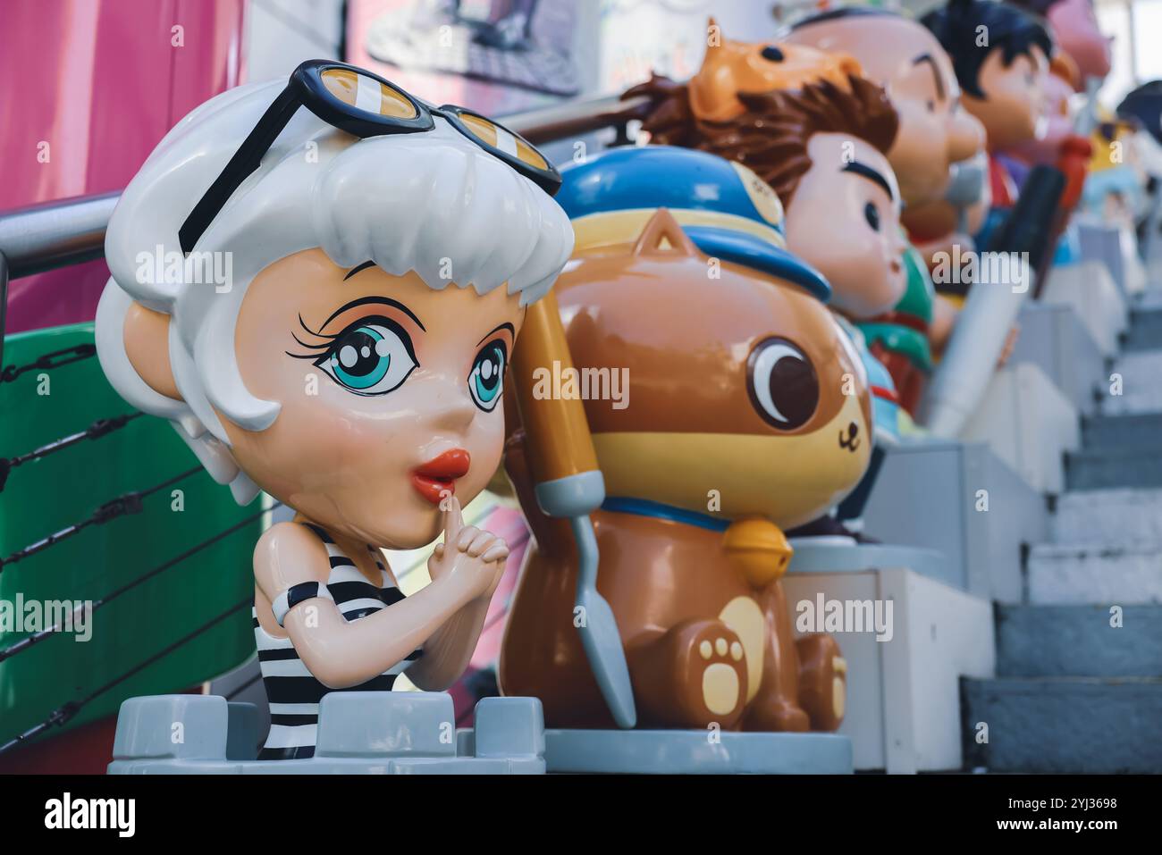 Des personnages de dessins animés bordent les marches de Hong Kong, mettant en vedette des designs vibrants et des expressions ludiques dans un décor urbain animé. Banque D'Images