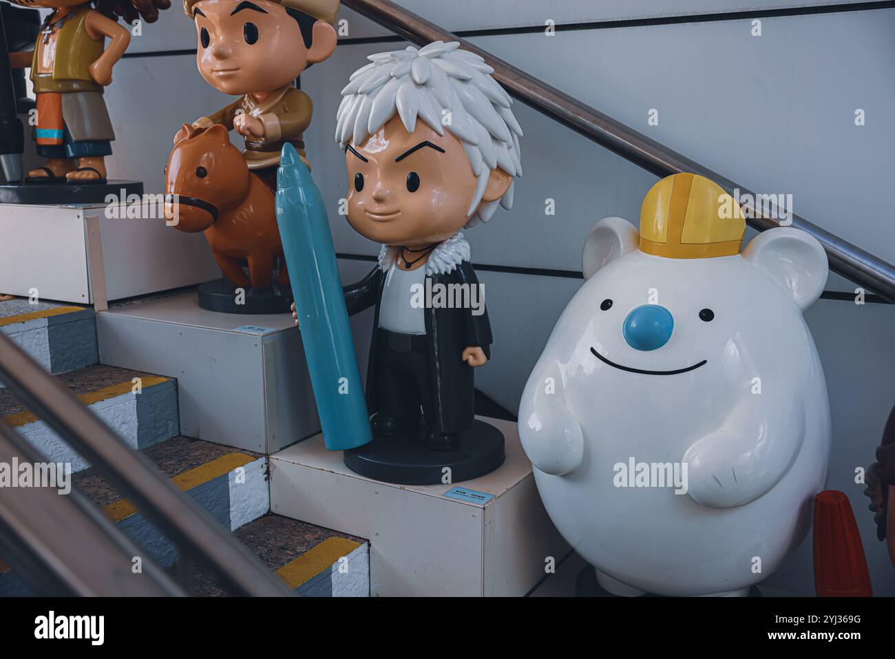 Des personnages de dessins animés colorés décorent les marches d'une rue animée de Hong Kong, invitant les visiteurs à explorer l'atmosphère vibrante. Banque D'Images