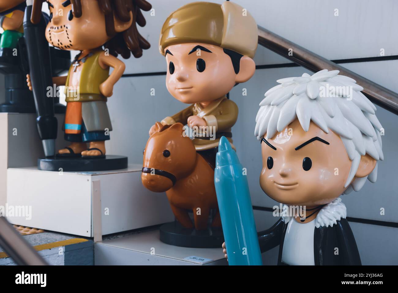 Des personnages de dessins animés colorés sont présentés le long d'une rue, apportant une énergie ludique au cadre urbain dynamique de Hong Kong. Banque D'Images