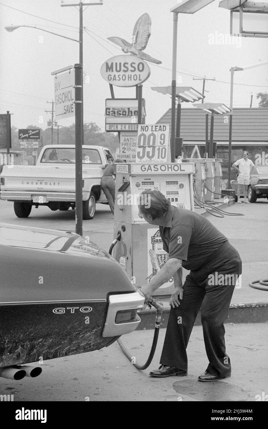 Homme à une station-service mettant du gasahol dans sa voiture. ÉTATS-UNIS. 20 juillet 1979 Banque D'Images