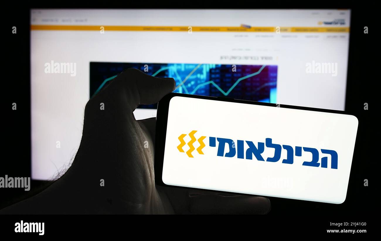 Allemagne. 08 juillet 2024. Dans cette illustration photo, un homme tient un téléphone portable avec le logo de la société First International Bank of Israel Ltd (FIBI) devant la page Web. Crédit : SOPA images Limited/Alamy Live News Banque D'Images