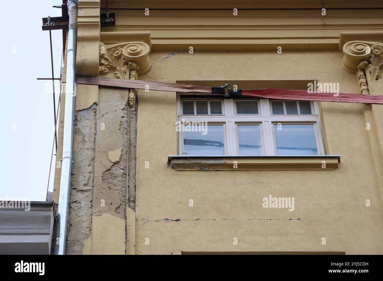 Dans le centre strict de Zagreb, dans la rue Masarykova, la vue d'un mur à pignon fissuré maintenu par des poutres et une structure en bois est devenue un symbole des problèmes à long terme de reconstruction après le tremblement de terre de mars 2020. Le bâtiment, où des entrepreneurs et un politicien bien connu auraient des appartements, a besoin d'une rénovation urgente. Malgré cela, la situation reste inchangée en raison de désaccords entre les conservateurs de la ville et les experts en statique, ce qui empêche de nouvelles étapes dans la restauration. Les gens passent sous cette partie dangereuse du bâtiment qui constitue le passage du Bak Banque D'Images