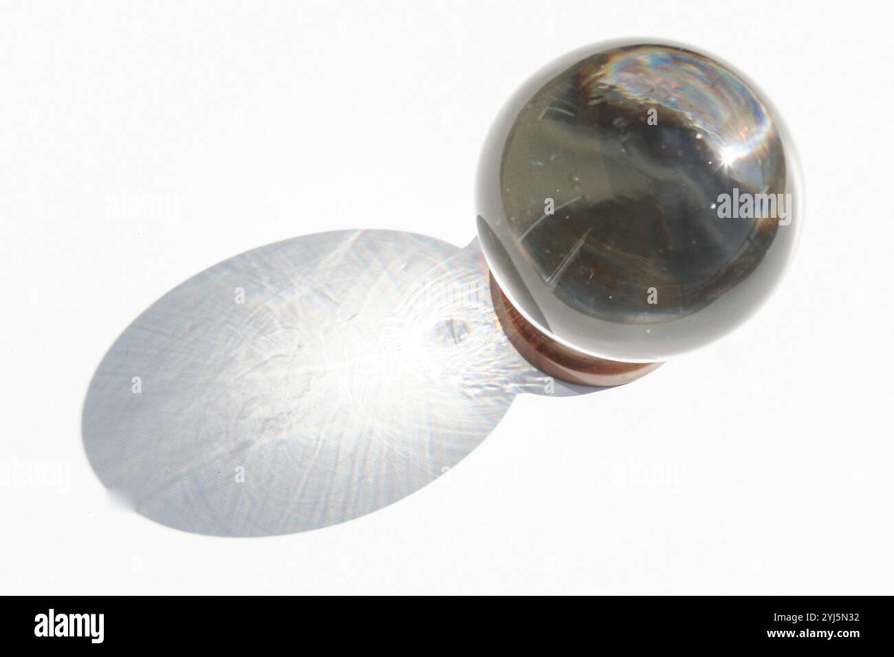 Boule de cristal sur fond blanc avec ombre projetée, image abstraite inspirante Banque D'Images