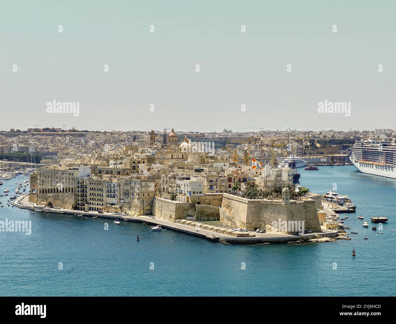 Vue aérienne de la ville fortifiée historique de Senglea, entourée par les eaux bleues du Grand Port, avec des bateaux et des yachts à proximité. Banque D'Images