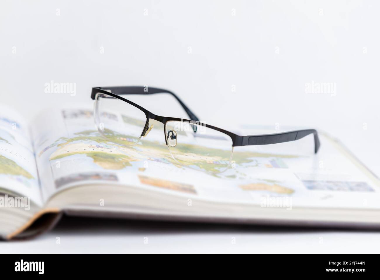 Lunettes reposant sur un livre ouvert, symbolisant la relaxation après une recherche et une étude intenses. Idéal pour les concepts d'apprentissage, de concentration, de travail académique et d'intel Banque D'Images