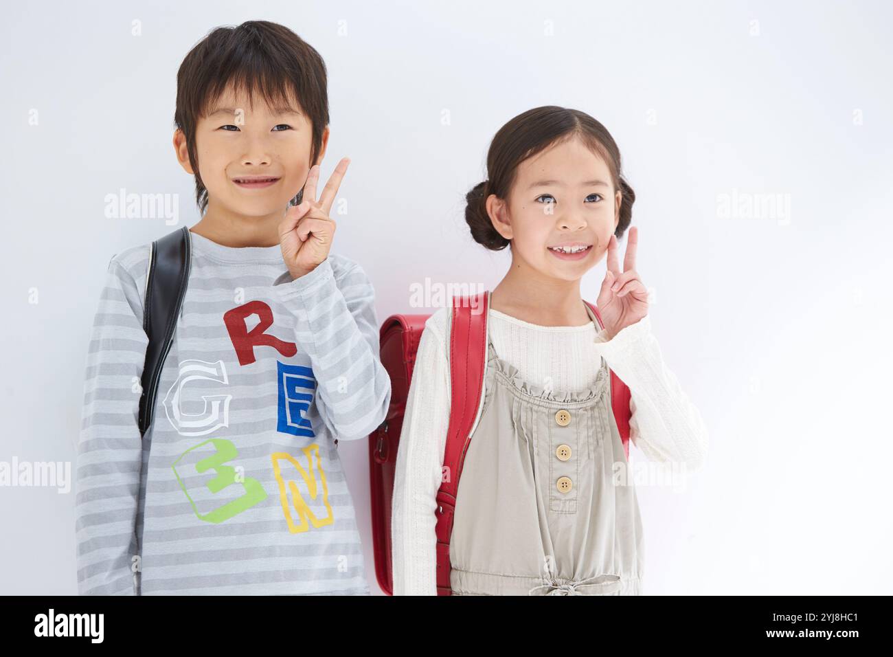 Garçons et filles de l'école primaire inférieure avec des sacs d'école Banque D'Images