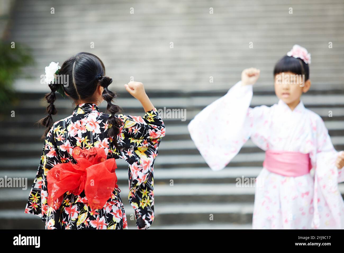 Fille en yukata jouant rock-papier-ciseaux Banque D'Images