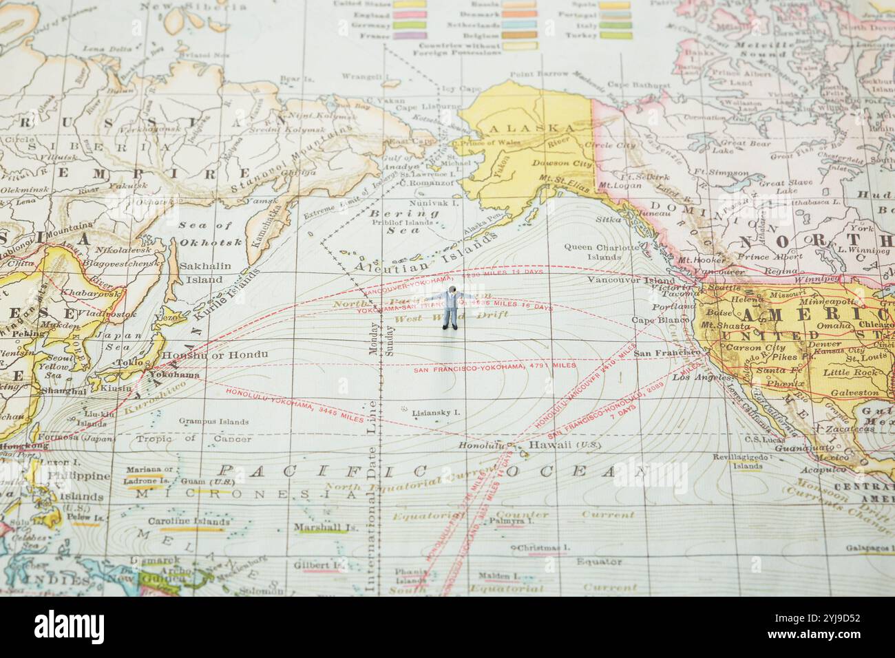 Homme d'affaires miniature étalant ses mains sur une carte du monde Banque D'Images