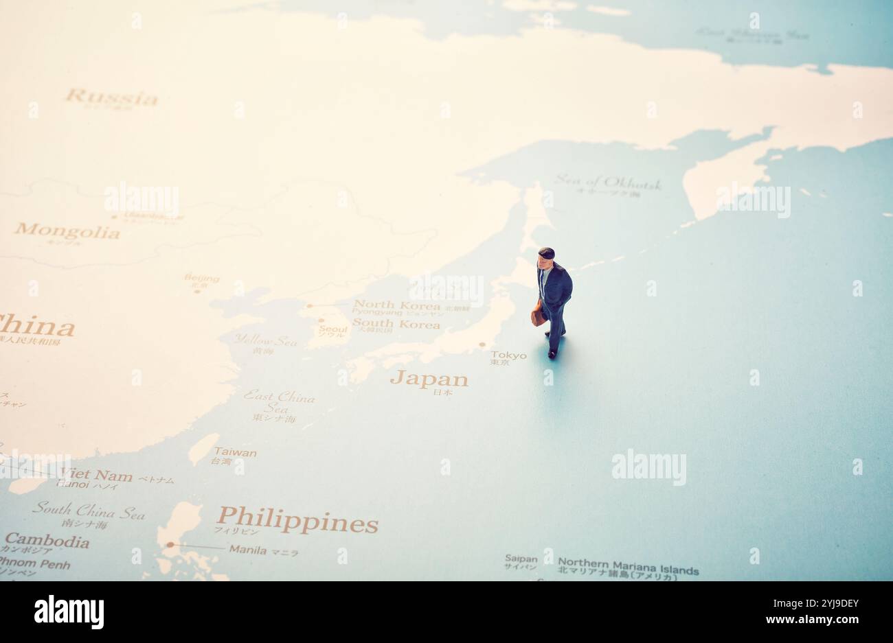 Poupée miniature debout par le Japon sur la carte du monde Banque D'Images