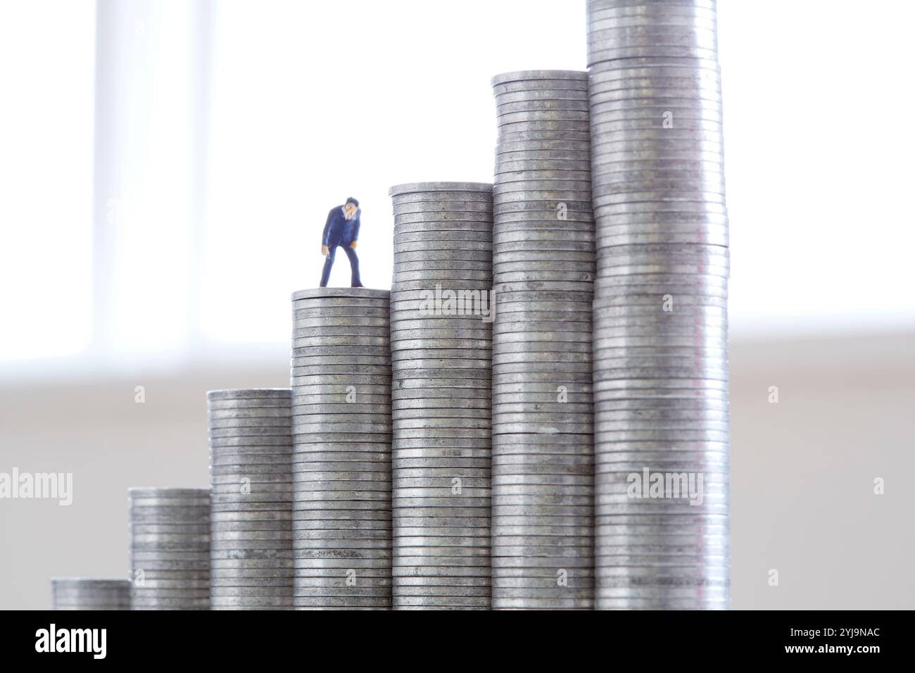 Pile de pièces d'un yen et de personnages miniatures Banque D'Images