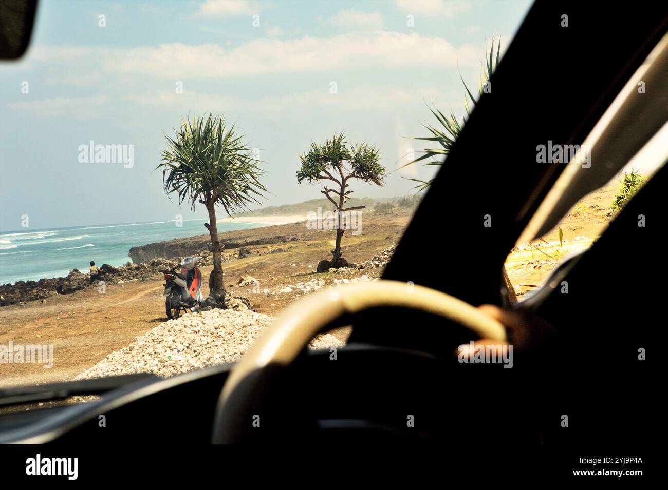 Un paysage de plage rocheuse est vu de l'intérieur d'une voiture à Pero Batang villlage, Kodi, Southwest Sumba, East Nusa Tenggara, Indonésie. Banque D'Images