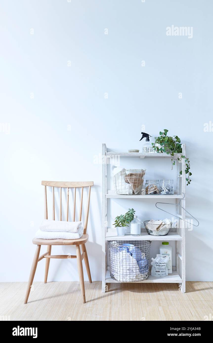 Porte-linge et chaise devant le mur blanc Banque D'Images