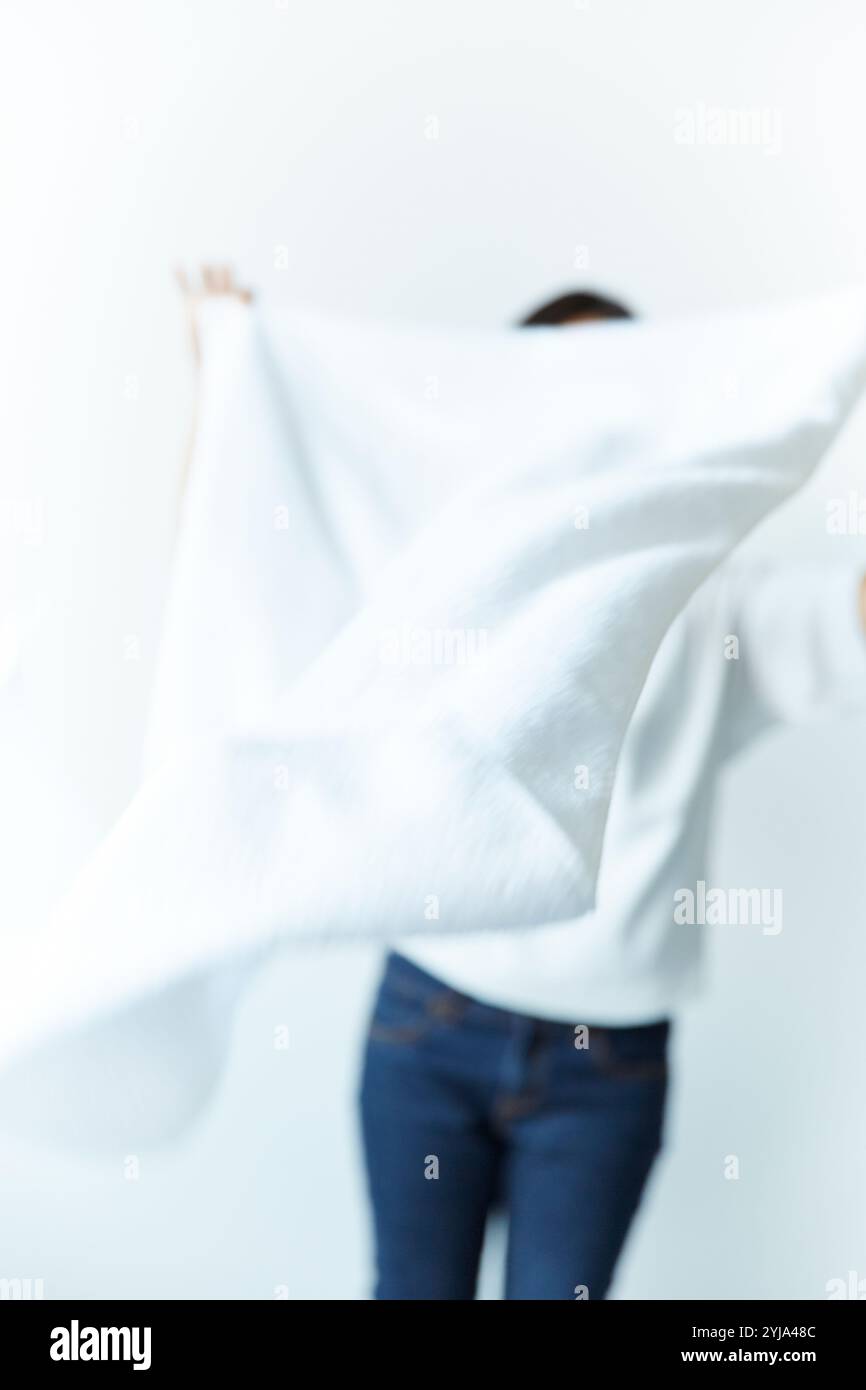 Femme étalant le drap blanc Banque D'Images