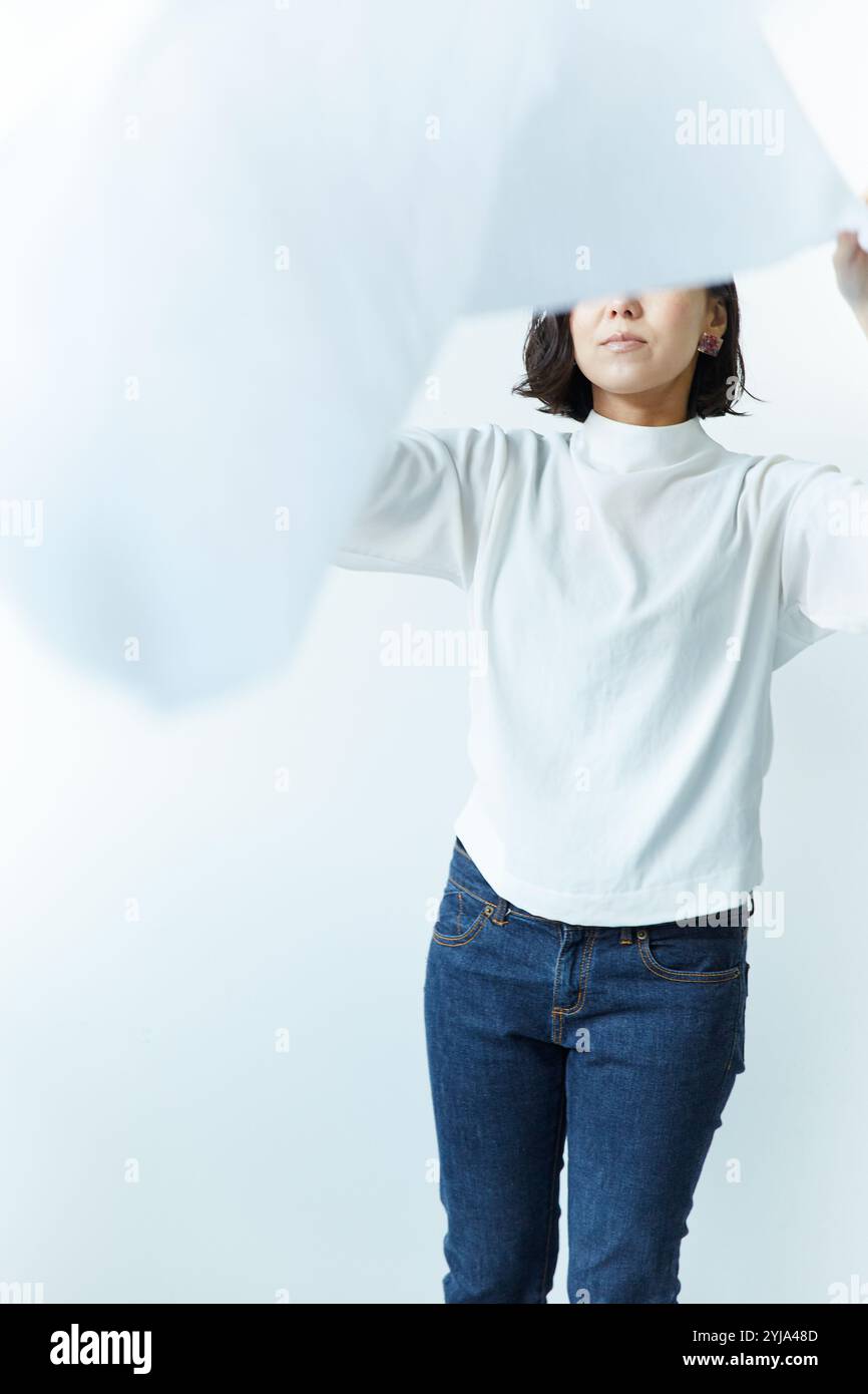 Femme étalant le drap blanc Banque D'Images