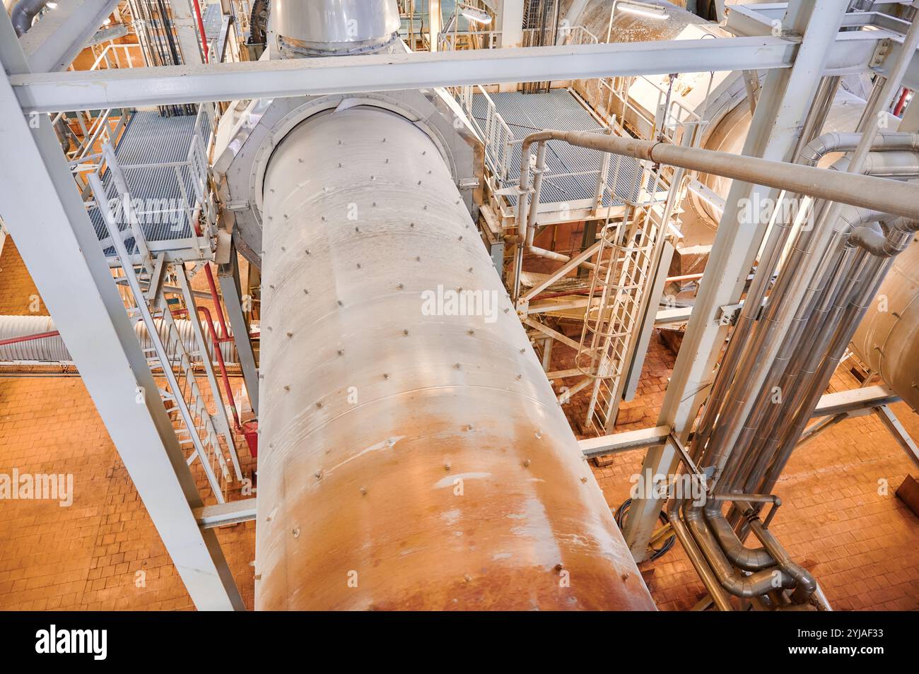 Vue d'ensemble de l'intérieur d'une usine chimique avec de vastes pipelines et un système de convoyage en fonctionnement pendant les heures de jour Banque D'Images