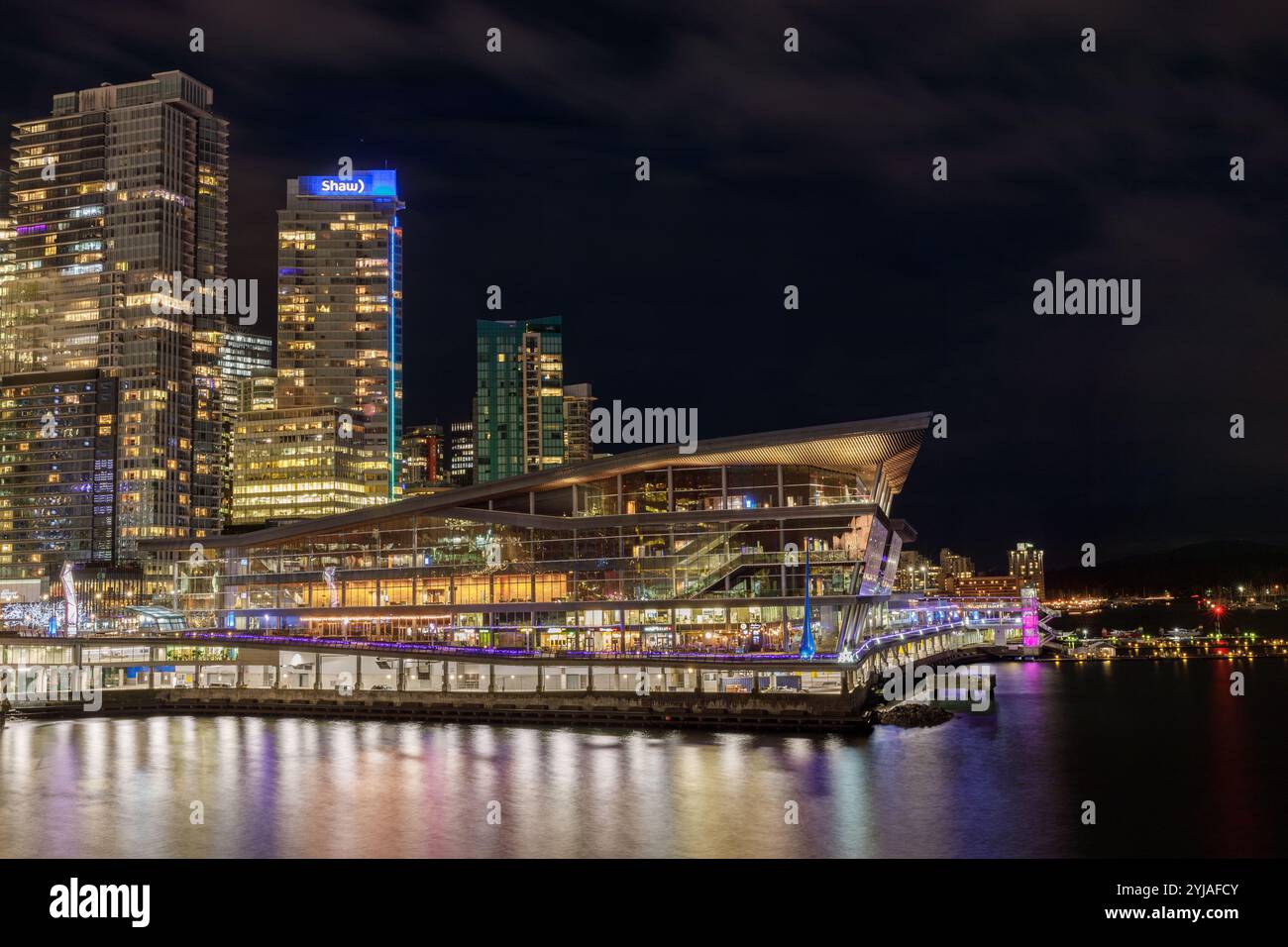 Vancouver, Canada - 3 janvier 2024 : Vancouver Convention Centre la nuit avec un toit incliné emblématique, installé contre les gratte-ciel illuminés du centre-ville Banque D'Images