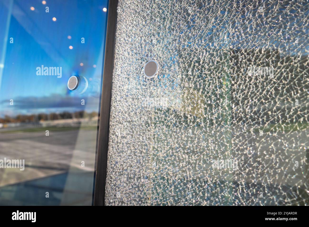Façade de bâtiment endommagée avec verre multicouche brisé. Réparation de façade, fissures de verre et assurance Banque D'Images