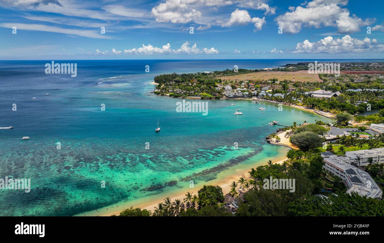 Cette photo aérienne capture une plage à Maurice, mettant en vedette des bateaux naviguant dans l'eau. Banque D'Images