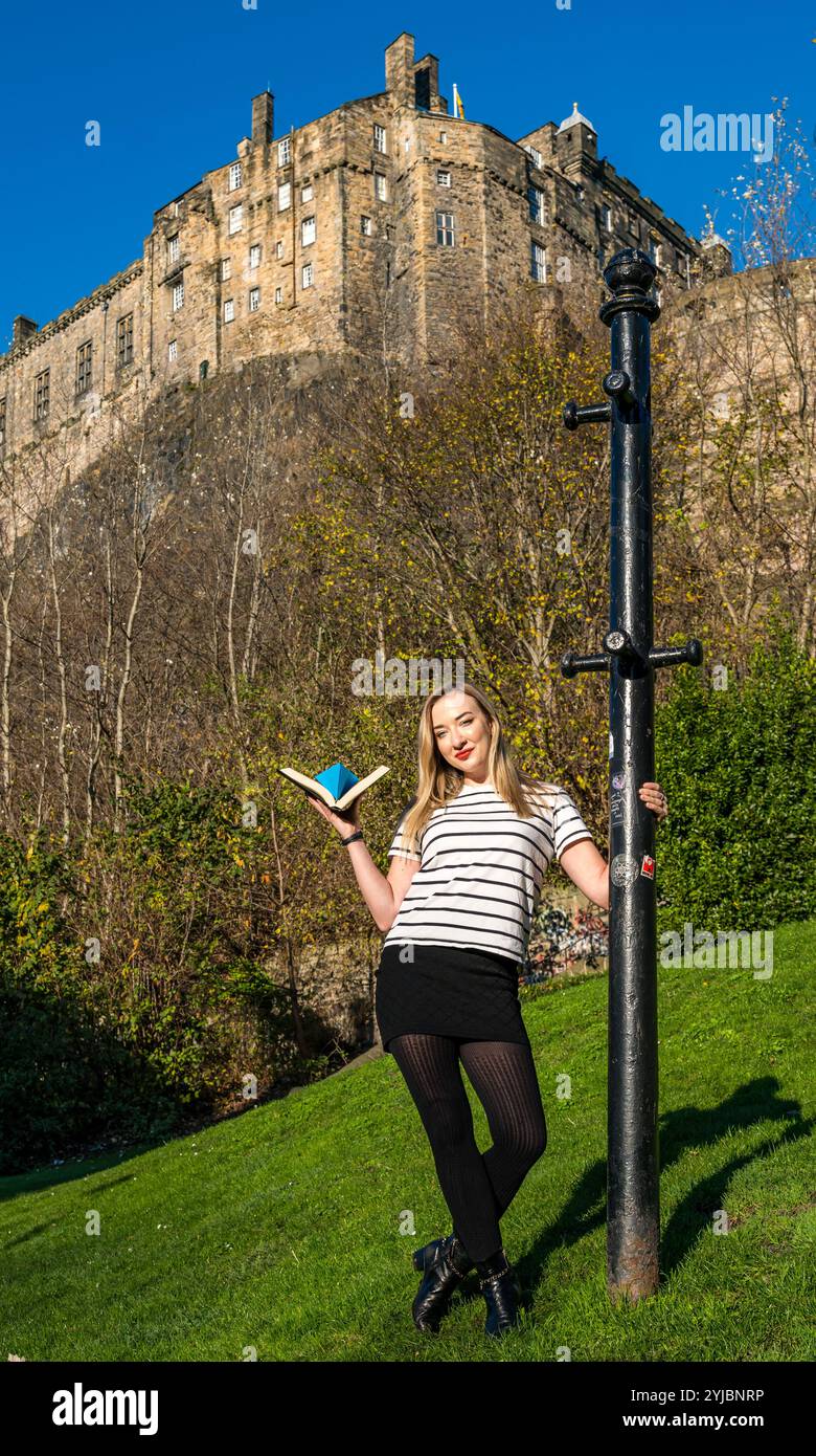 Édimbourg, Écosse, Royaume-Uni, 14 novembre 2024, Push the Boat Out : la chanteuse folklorique primée Iona Fyfe pose avec un bateau en papier origami sous l’emblématique château d’Édimbourg pour promouvoir le festival national de poésie écossais. Iona sera la tête d'affiche d'une soirée de chansons fusionnées de poésie. Crédit : Sally Anderson/Alamy Live News Banque D'Images