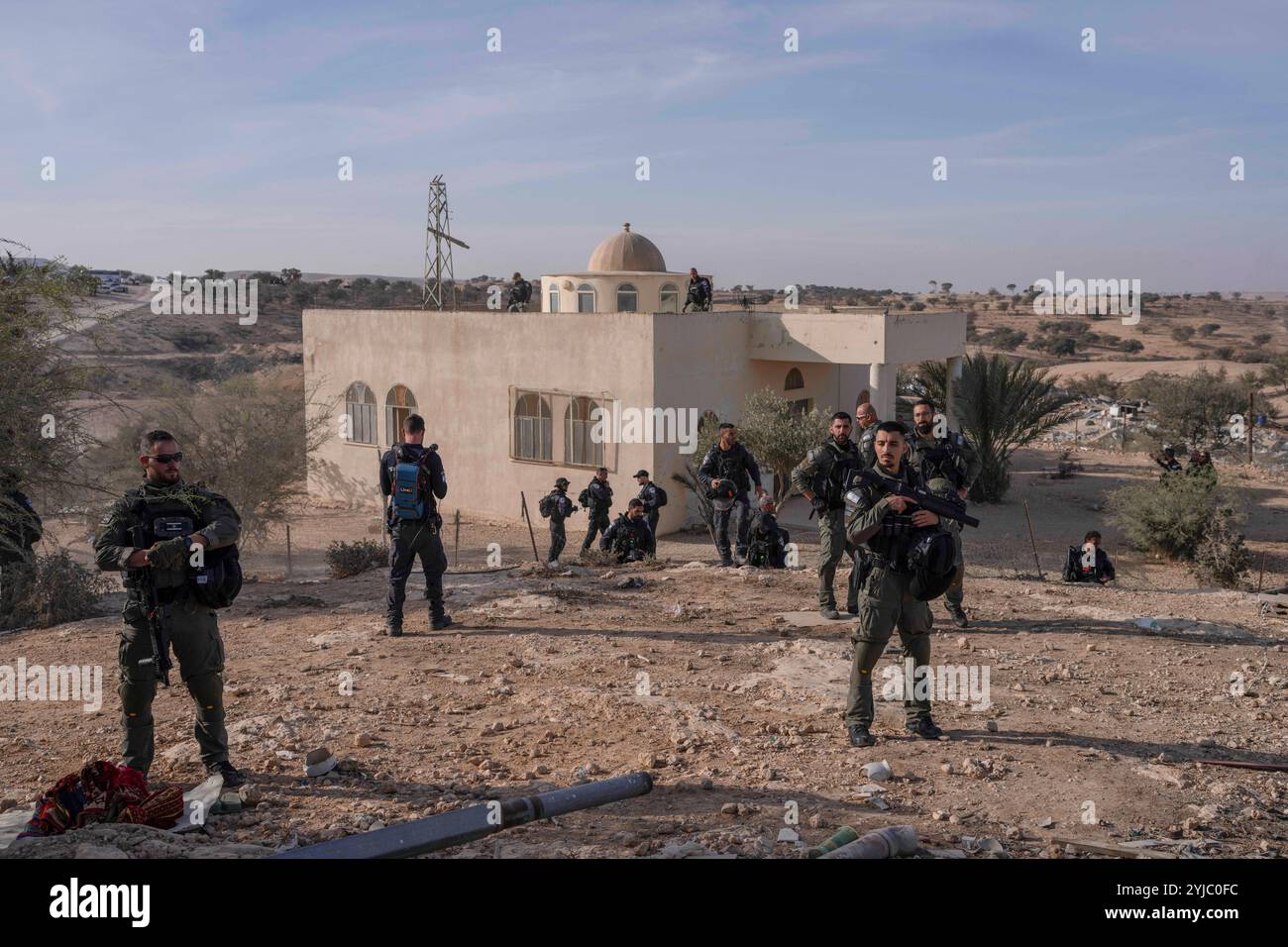 Umm Al Hiran, Israël. 14 novembre 2024. Des policiers israéliens surveillent la démolition du village bédouin d'Umm al-Hiran dans le désert du Néguev. Les dernières structures restantes du village bédouin non reconnu d'Umm al-Hiran, colonisé par la tribu Abu Alkian depuis 1956, sont démolies pour laisser place à la communauté juive orthodoxe planifiée de Dror. Crédit : Ilia Yefimovich/dpa/Alamy Live News Banque D'Images