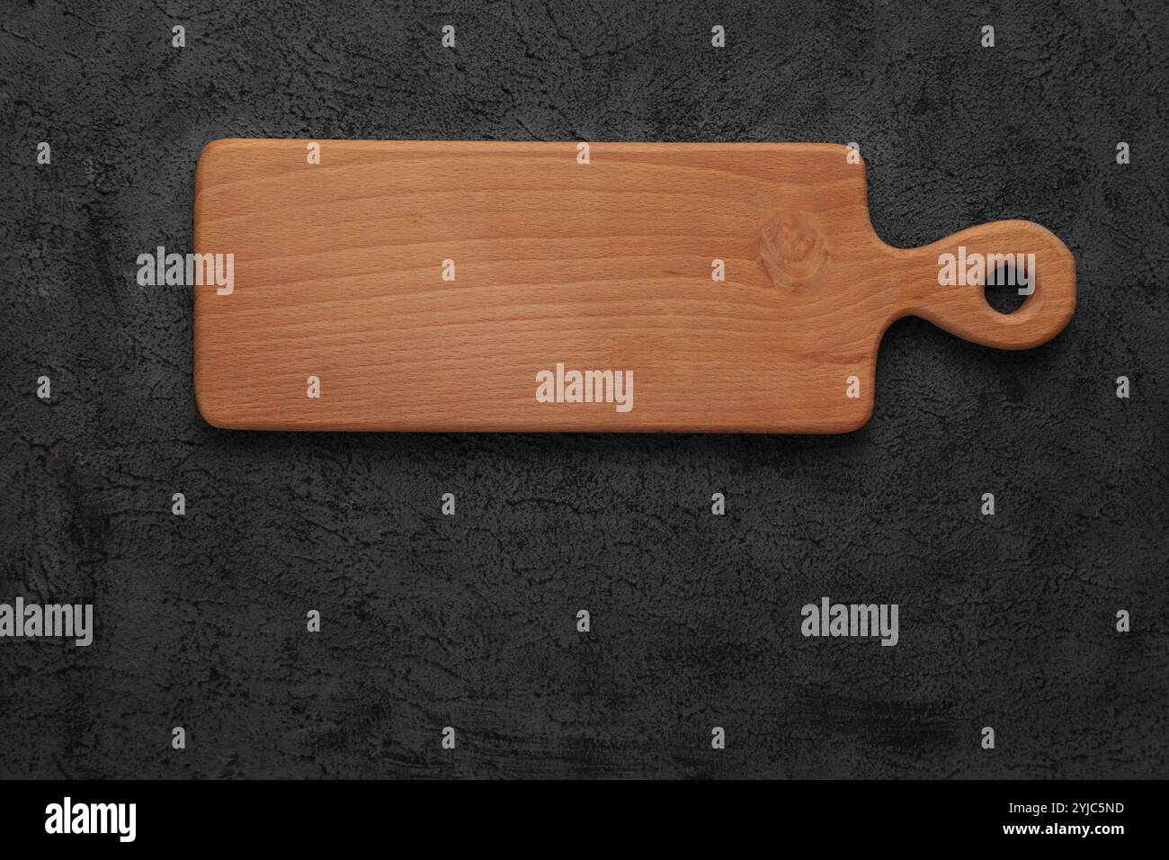 Planche à découper en bois brun vide sur fond de ciment noir. Vue de dessus, espace de copie. Maquette carrée Banque D'Images