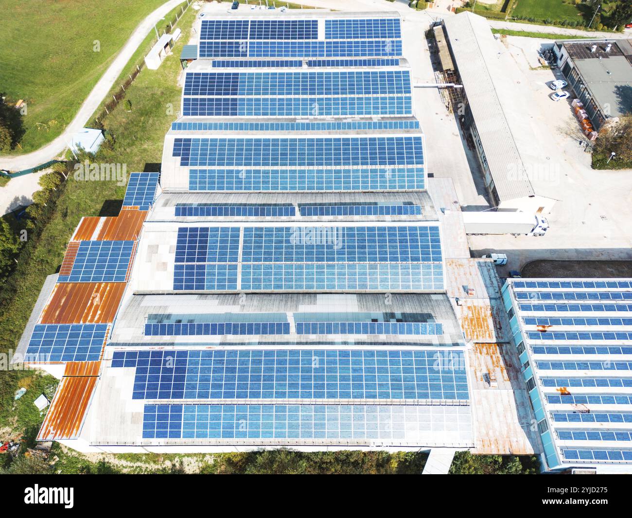 Panneaux solaires installés sur le toit d’un grand bâtiment industriel ou d’un entrepôt. Bâtiment industriel dans la campagne de la Slovénie avec résidentiel h Banque D'Images