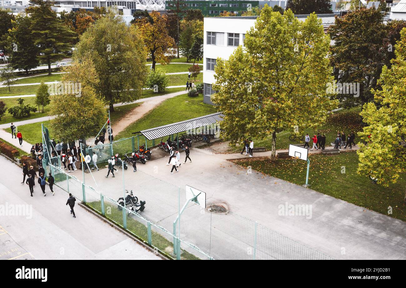 Vue aérienne des étudiants marchant à l'extérieur sur le campus allant et sortant de la classe. Jour d'automne, beaucoup d'arbres et d'herbe verte sur le campus Banque D'Images