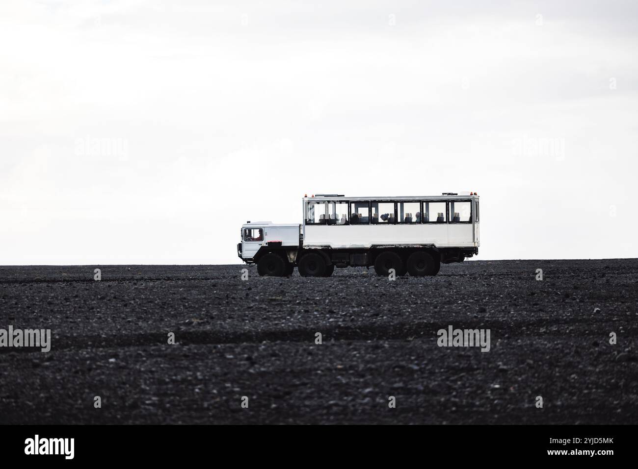 Voiture conduisant les touristes sur la plage de sable noir de Selheimasandur dans le sud de l'Islande. Banque D'Images