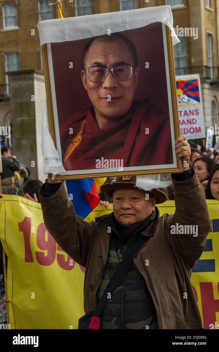 Londres, Royaume-Uni. 10 mars 2018. Un homme présente une photographie encadrée du Dalaï Lama au rassemblement de Downing St avant la marche annuelle pour la liberté du Tibet à l'ambassade de Chine. L'événement commémorait le 59e anniversaire du soulèvement national tibétain. Avant le départ de la marche, il y avait une minute de silence pour ceux qui sont morts, y compris par auto-immolation, et une longue prière tibétaine, suivie du chant de l'hymne national tibétain. Banque D'Images