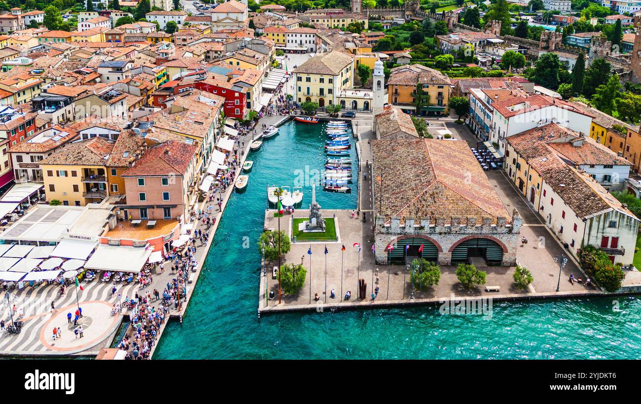 LAZISE, ITALIE – 21 AOÛT 2024 : Porto Lazise sur le lac de Garde, avec son front de mer historique, ses eaux calmes et ses bateaux amarrés le long du quai, reflète le Banque D'Images
