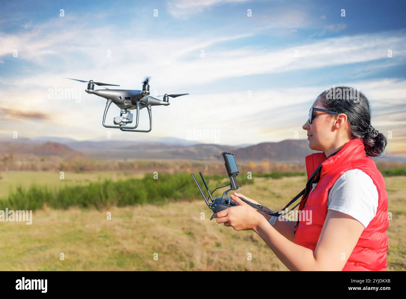Une jeune femme contrôle un drone. Banque D'Images