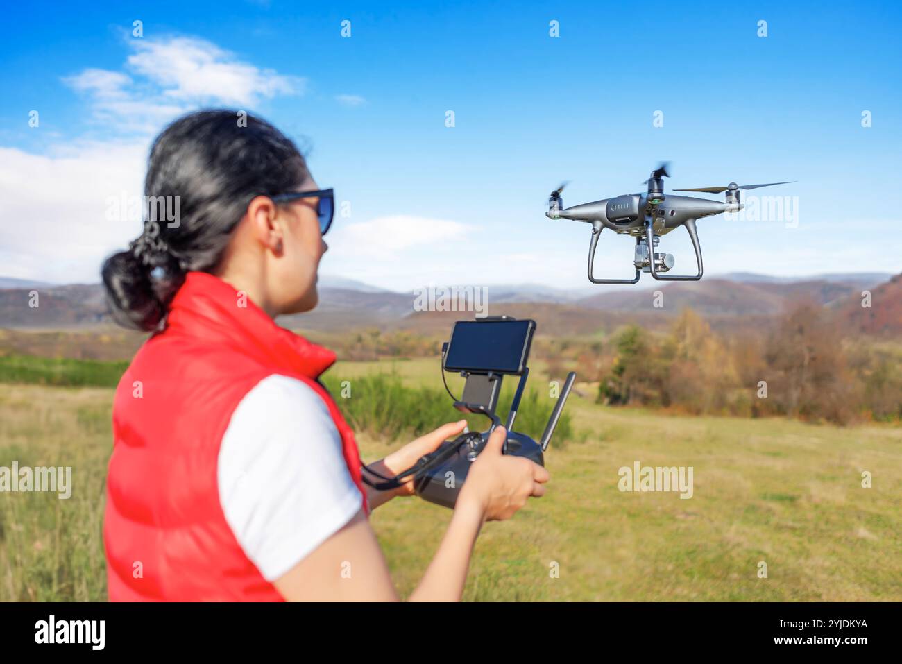 Une jeune femme contrôle un drone. Banque D'Images