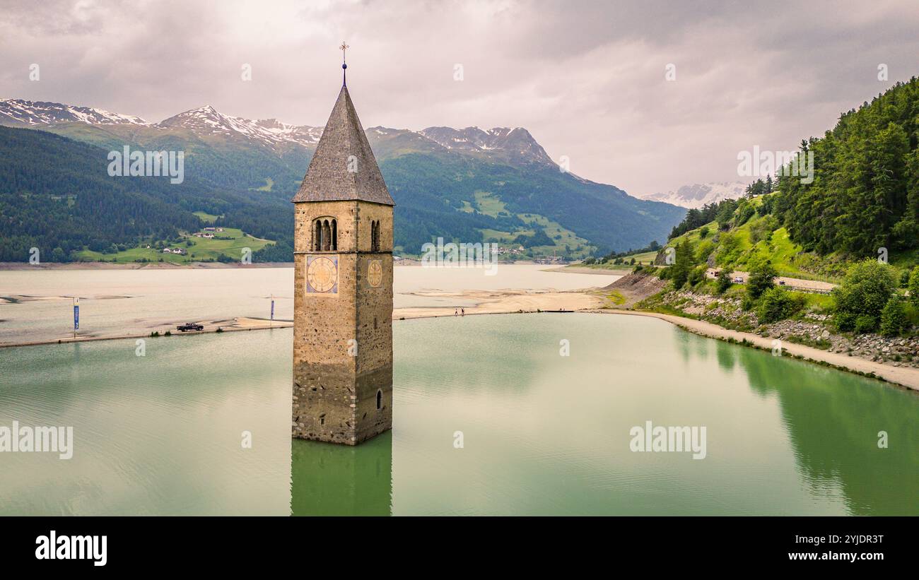 CURON VENOSTA, ITALIE – 27 AOÛT 2024 : le clocher emblématique de l’église submergée Curon Venosta s’élève des eaux du lac Resia, une Ré envoûtante Banque D'Images