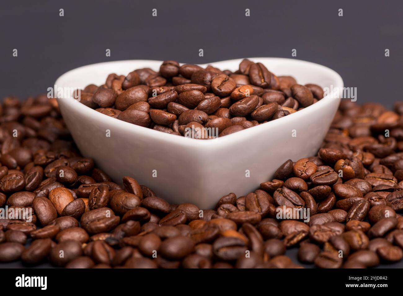 Grains de café torréfiés dans un plat blanc Banque D'Images