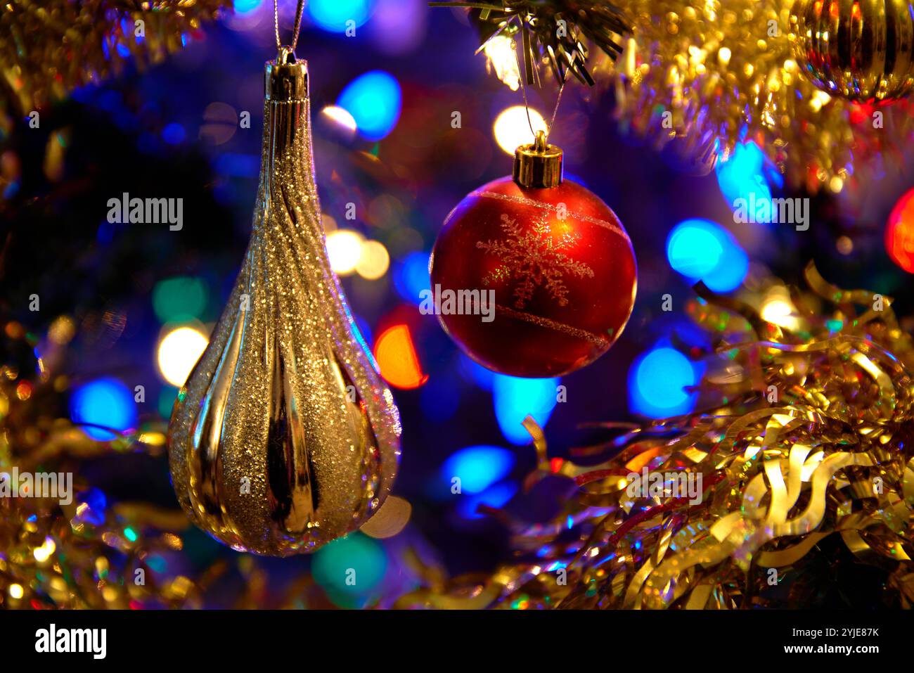 Sapin de Noël à boules argentées et rouges. Décorations festives de vacances sur un arbre de Noël. Banque D'Images