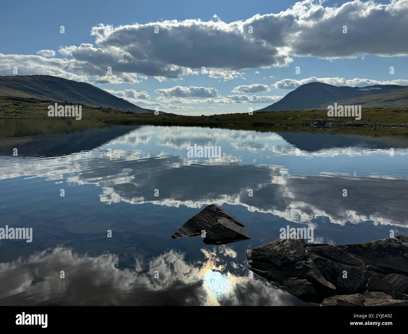 Nuages blancs reflétés dans le lac de montagne Banque D'Images