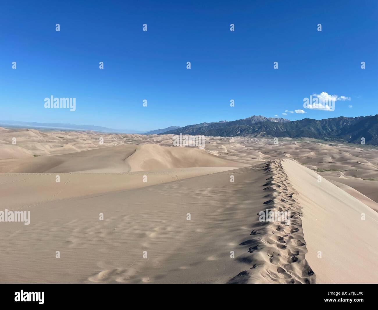 Empreintes sur les dunes de sable avec des montagnes en arrière-plan - Image de stock capturée avec un smartphone