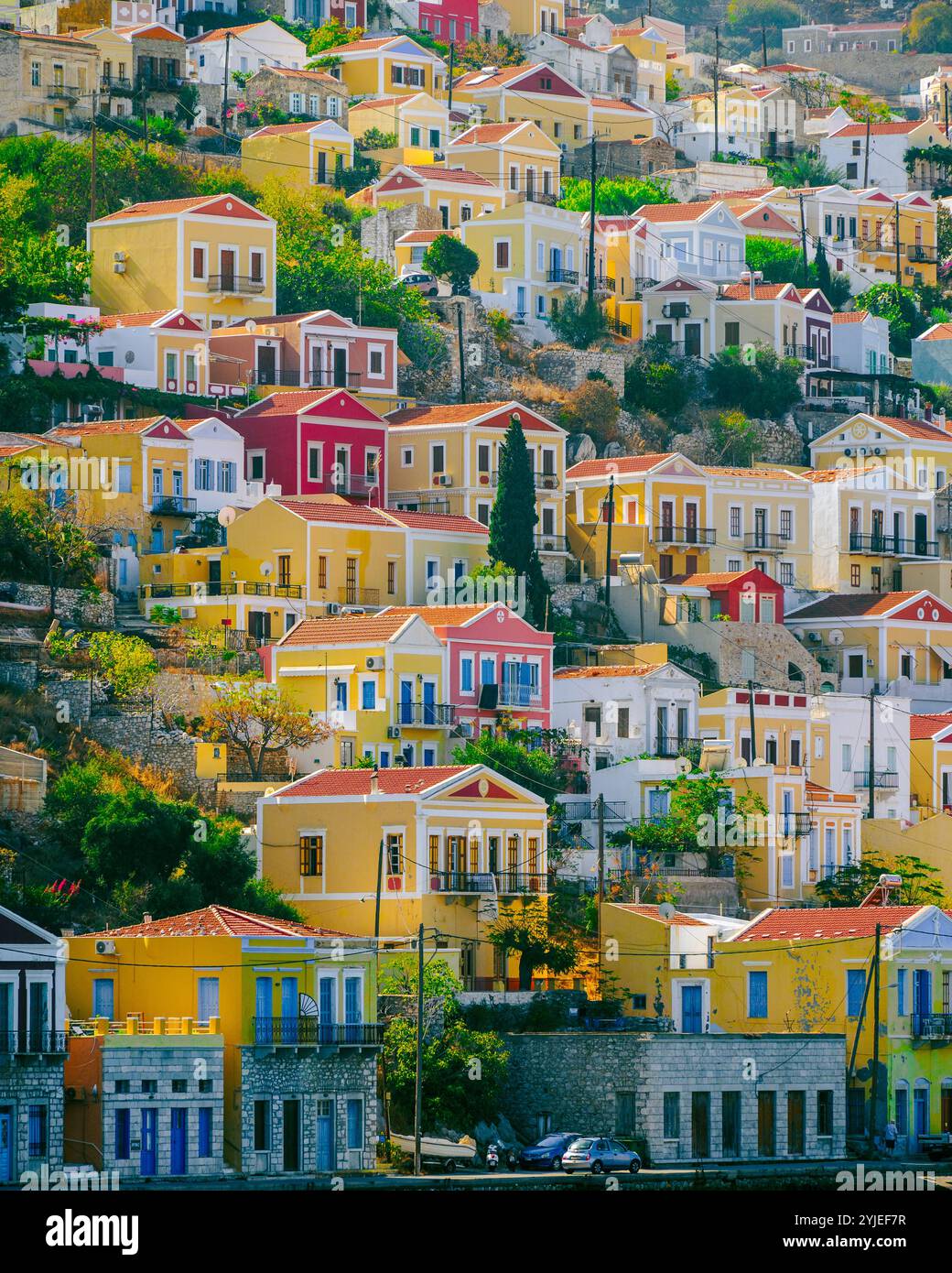 Maisons néoclassiques colorées sur le flanc de la colline de l'île de Symi, Dodecanèse, Grèce Banque D'Images