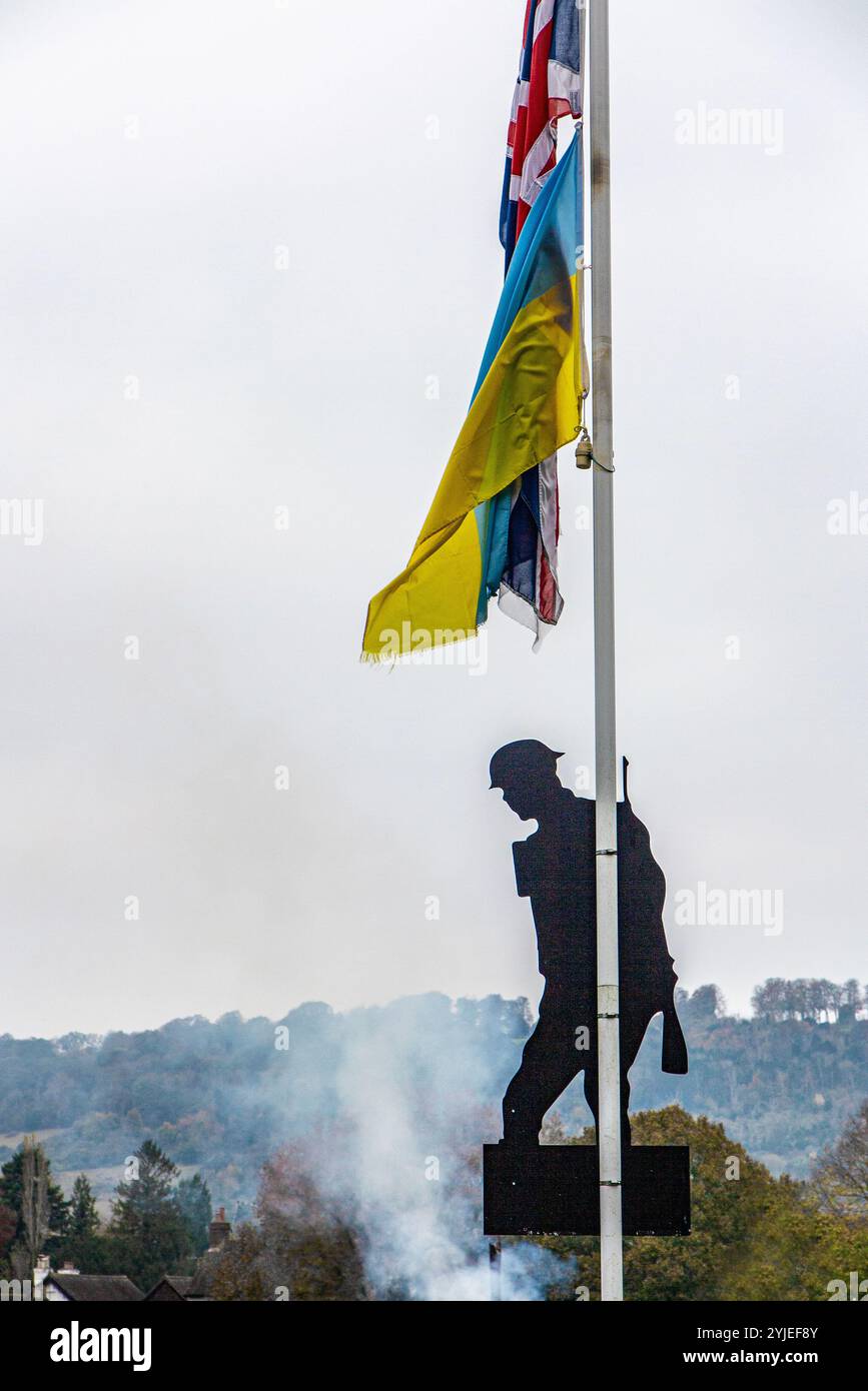 Silhouettes d'un soldat inconnu sur fond de drapeau ukrainien, fumée et destruction ne unissent pas la 1ère Guerre mondiale Banque D'Images