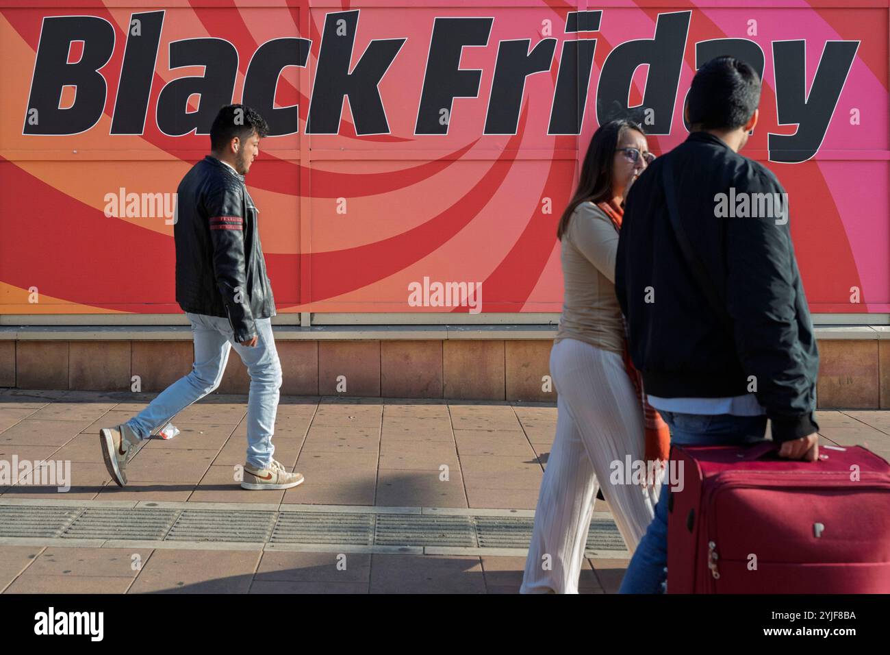 Madrid, Espagne. 14 novembre 2024. Les gens passent devant une bannière faisant la promotion des soldes du vendredi fou à venir et des offres de magasinage anticipé des fêtes. (Photo de Xavi Lopez/SOPA images/Sipa USA) crédit : Sipa USA/Alamy Live News Banque D'Images