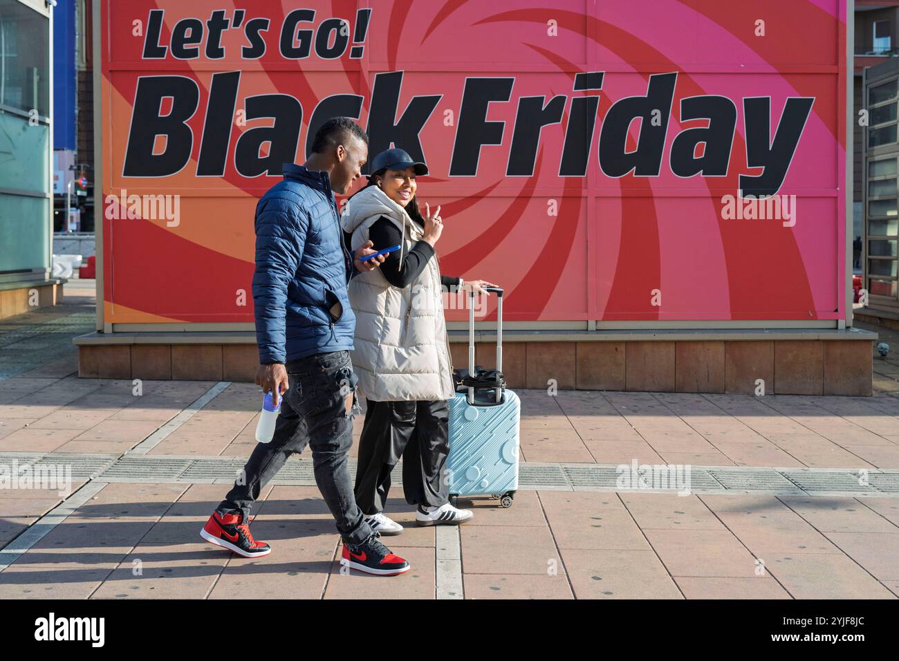 Madrid, Espagne. 9 novembre 2024. Les gens passent devant une bannière faisant la promotion des soldes du vendredi fou à venir et des offres de magasinage anticipé des fêtes. (Crédit image : © Xavi Lopez/SOPA images via ZUMA Press Wire) USAGE ÉDITORIAL SEULEMENT! Non destiné à UN USAGE commercial ! Banque D'Images
