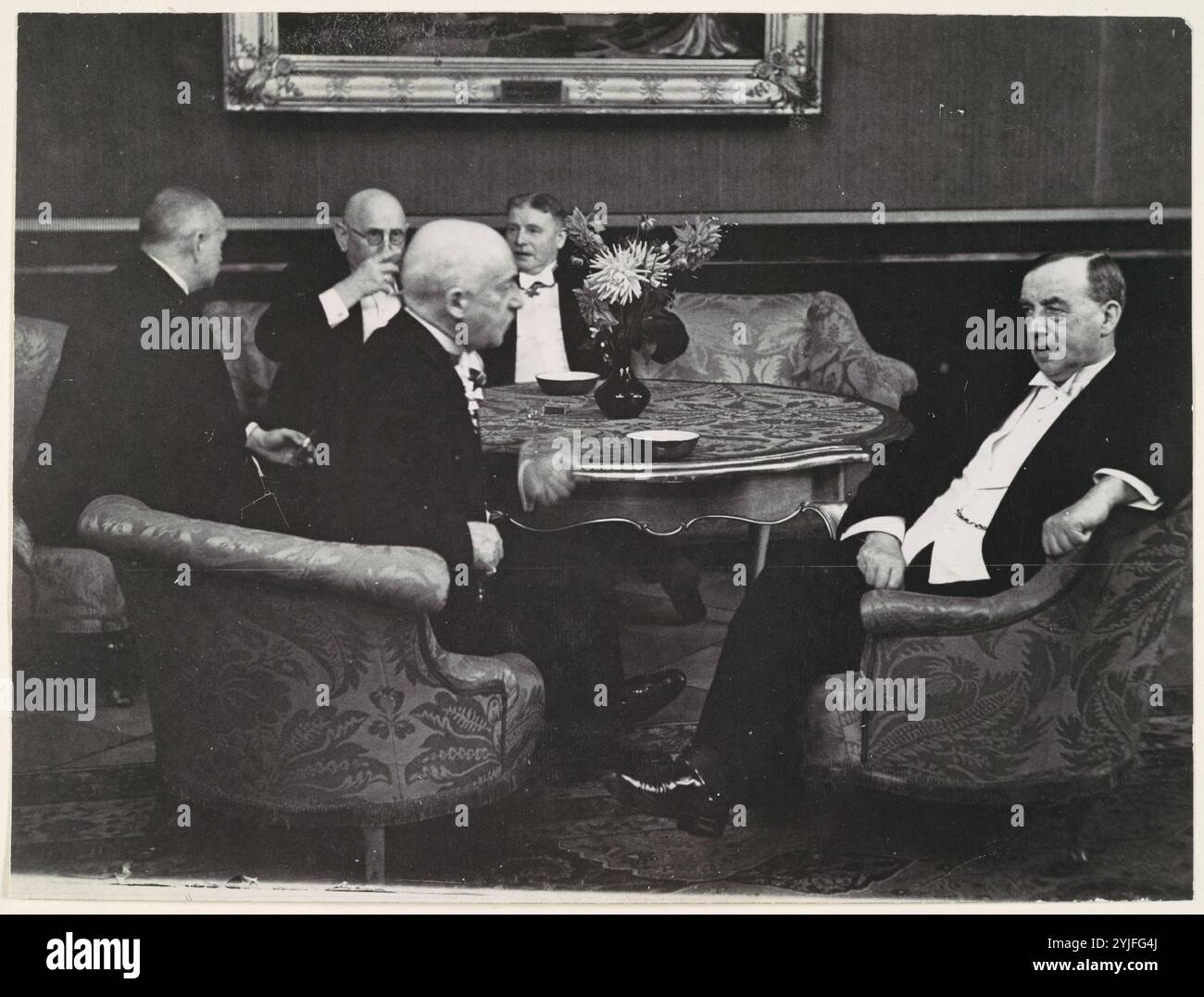 [Cinq messieurs conversant autour de la table]. Artiste : Erich Salomon (allemand, Berlin 1886-1944 Auschwitz, Pologne). Dimensions : 17,4 x 23,2 cm (6 7/8 x 9 1/8 po). Date : 1920s-30s. L'expression « caméra franche » a été inventée pour la première fois en 1929 pour décrire la technique idiosyncrasique de Salomon consistant à capturer les dirigeants politiques et industriels les plus puissants du monde se révélant comme des êtres humains ordinaires : parler, bâiller et plaisanter. Avec son appareil photo Ermanox de 35 mm dissimulé (parfois dans un chapeau ou une valise) et son apparence discrète, Salomon a pu couper à travers la façade lisse véhiculée par le STA officiel Banque D'Images