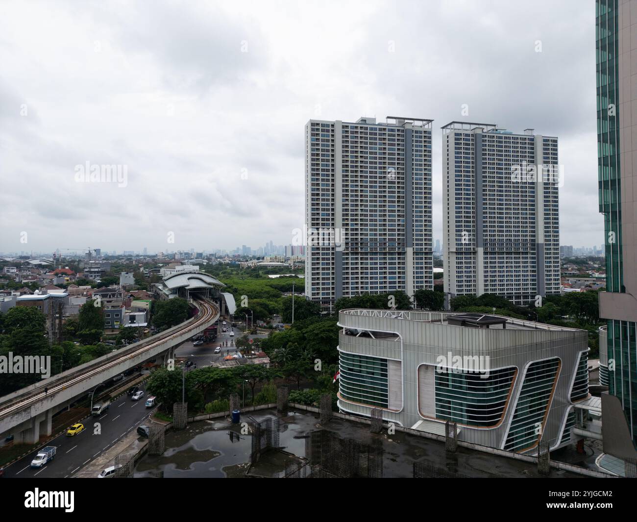 Vue aérienne du paysage urbain de Jakarta, mettant en valeur des appartements imposants de grande hauteur le long d'une gare animée, architecture moderne contre un d Banque D'Images