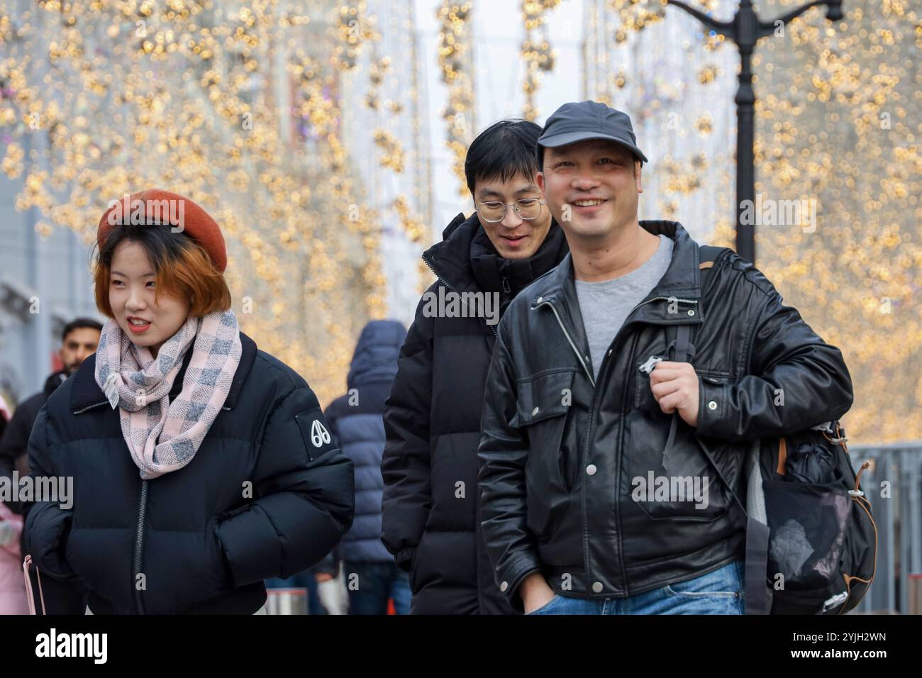 Heureux touristes chinois marchant sur la place Rouge à Moscou sur fond de décorations sur la rue Nikolskaya Banque D'Images