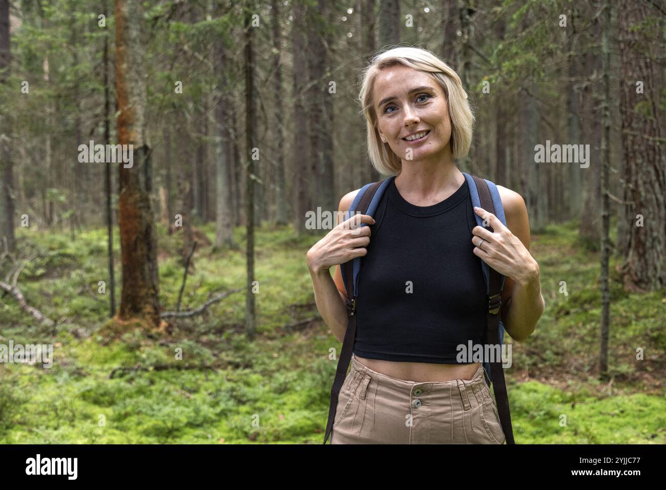 Femme blonde portrait avec sac à dos sur la randonnée en forêt Banque D'Images